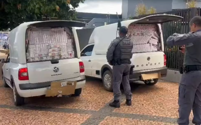 Polícia apreende maços de cigarro contrabandeados em compartimento de carga de veículos furgão em rodovia